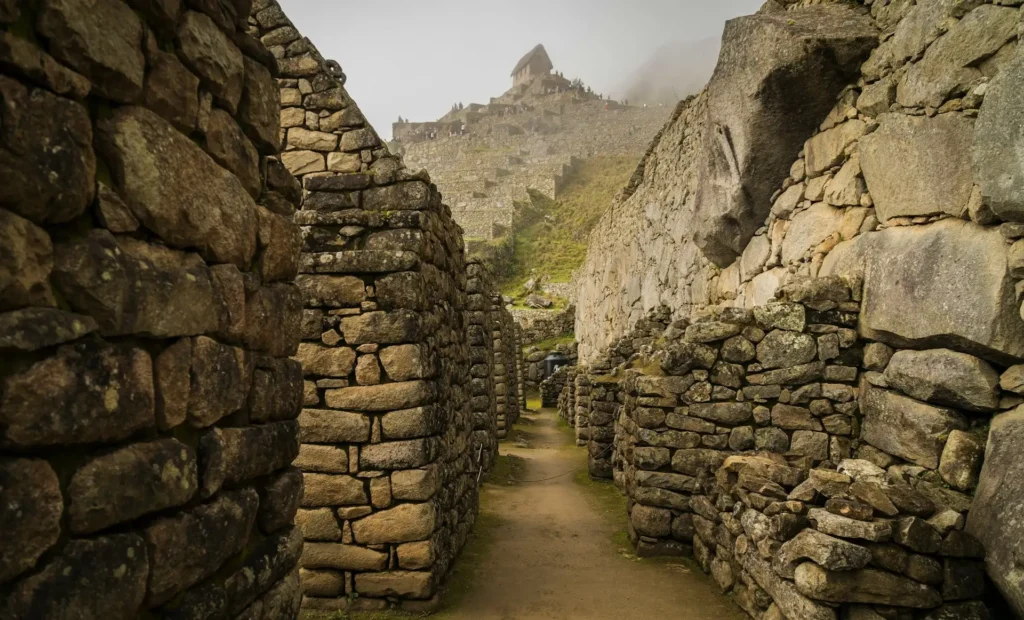 AC Partners- Photo-by-willian-justen-de-vasconcellos-kNbq1SHfLd8-unsplash - Machu Picchu'da harç kullanılmadan inşa edilmiş granit taş duvarların yakın plan görüntüsü, İnka mimarlığında milimetrik taş işçiliğini ve depreme dayanıklı tasarımı gösteriyor.